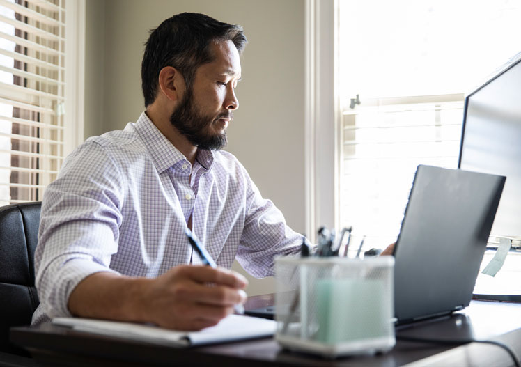 man working at desk with computer