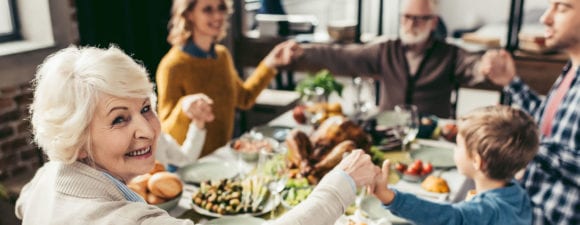 family praying at table during holiday