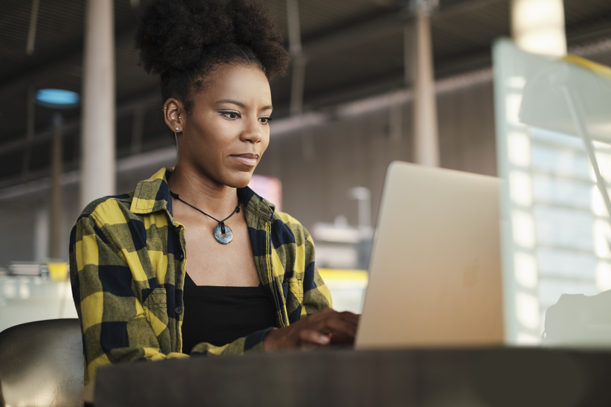 Confident woman working on laptop computer in library