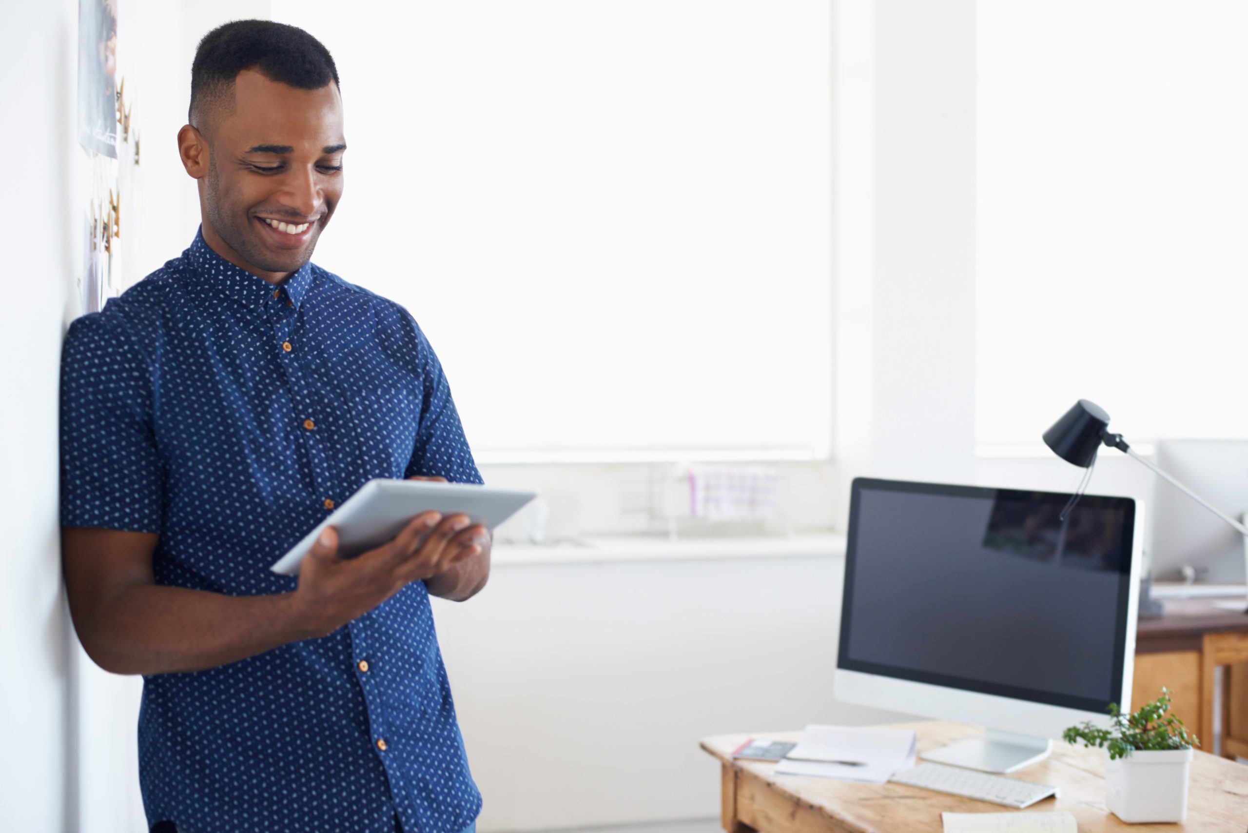 man standing looking at tablet