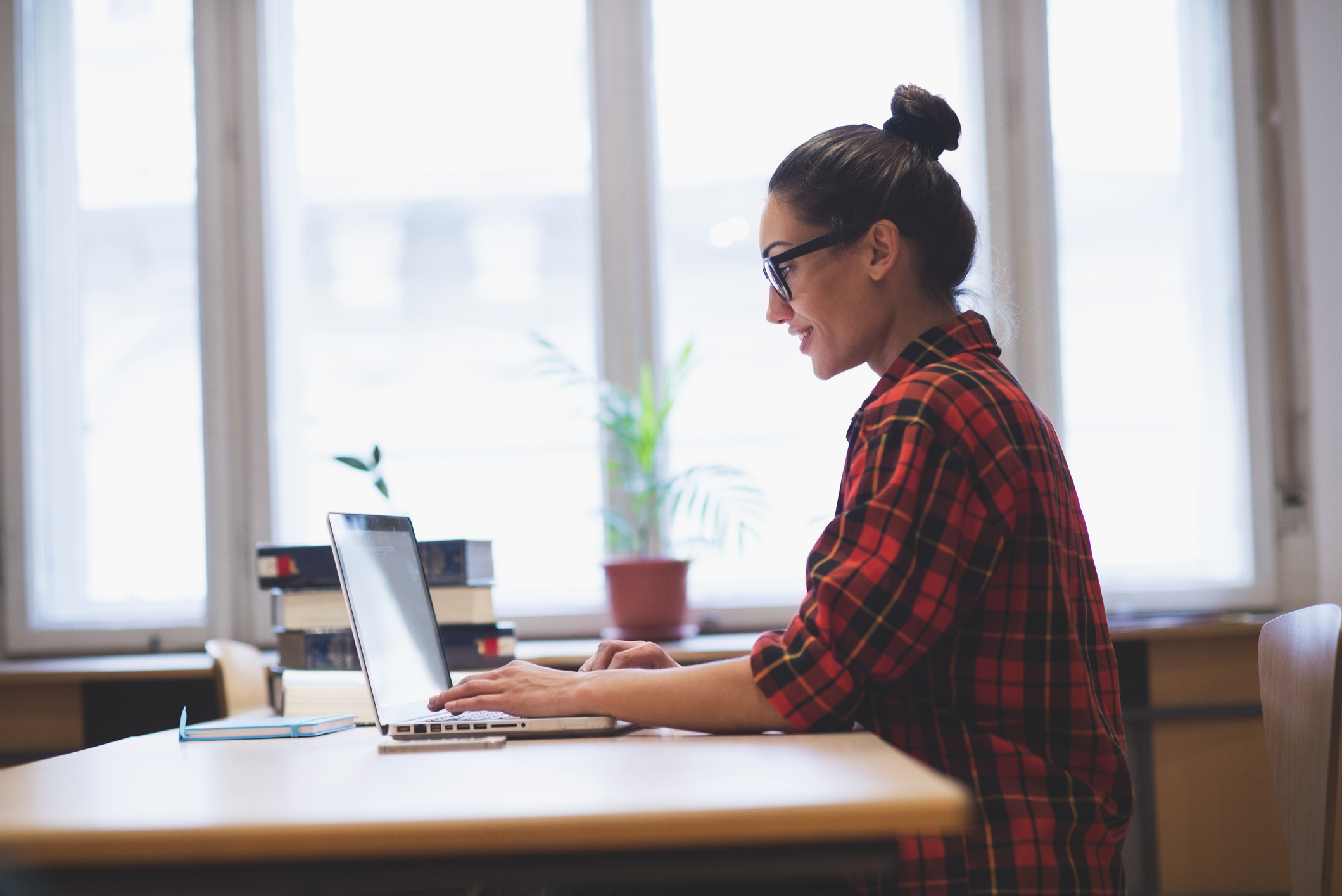 Young hipster girl working on laptop in the office