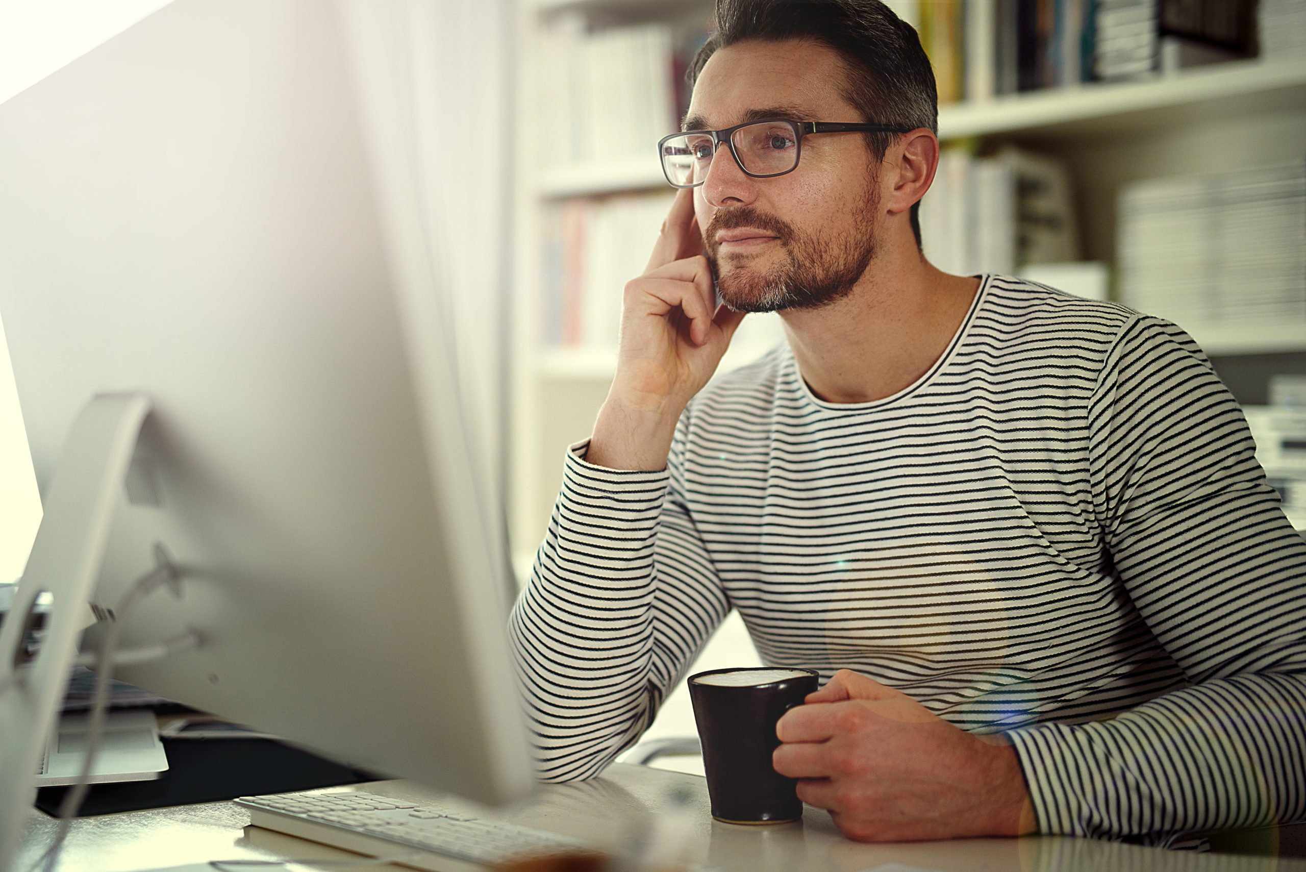 Man With Coffee looking at computer screen