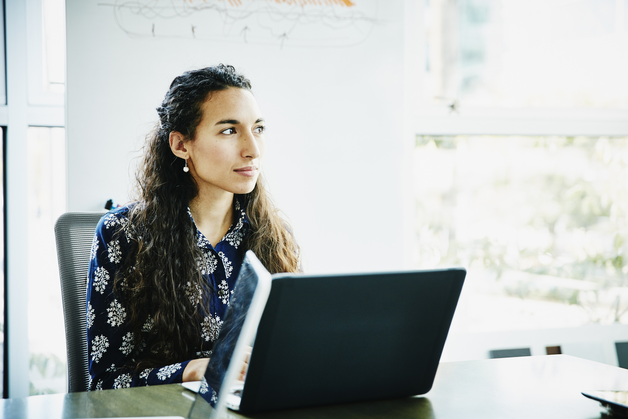 Businesswoman working on laptop in office conference room