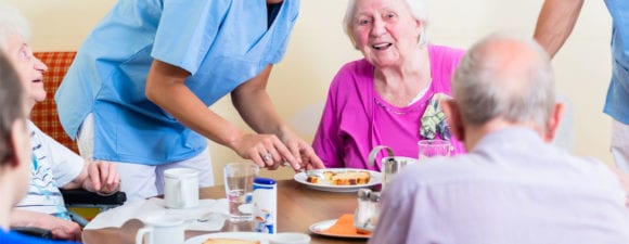 group of seniors eating lunch at nursing home