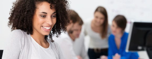 A woman using a learning management meant working on a computer to improve onboarding process