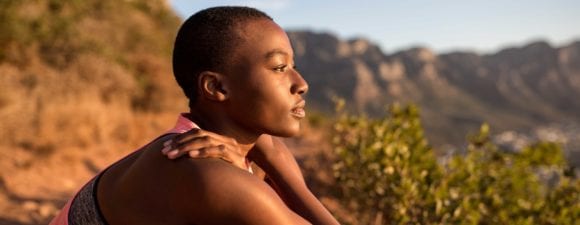 Black woman looking out on desert hiking trail.