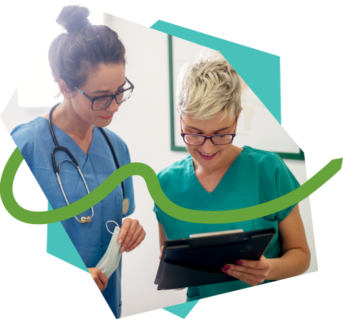 Two healthcare workers look at information on a tablet.