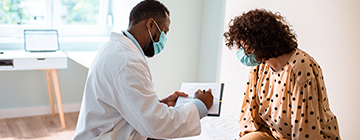 a doctor reviews a clipboard with a patient